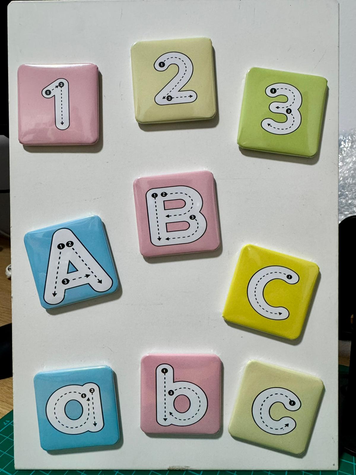 Set of colorful alphabet and number tiles on a white board