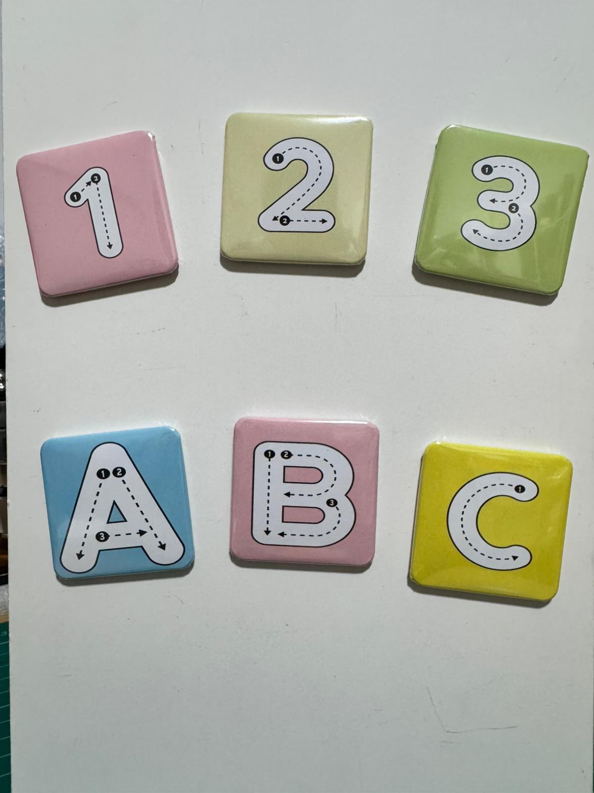 Set of colorful square magnets with numbers and letters on a white background